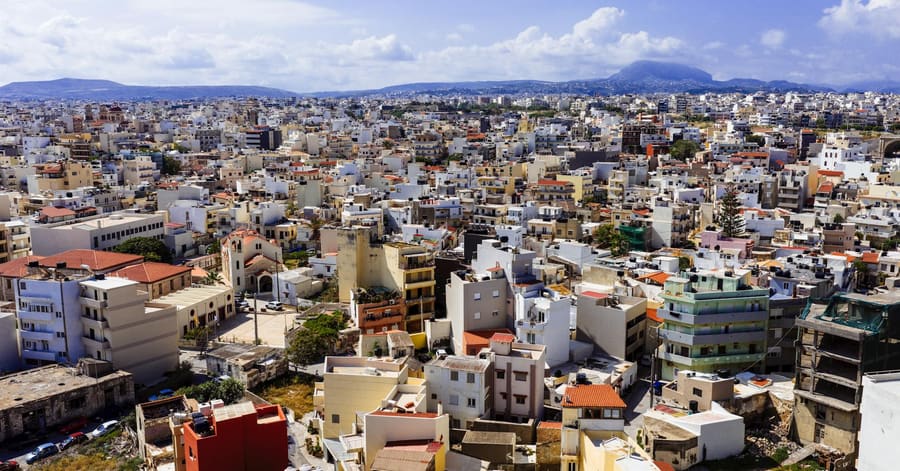 Discover the vibrant cityscape of Heraklion, Crete, captured from above with a stunning view of buildings and mountains.