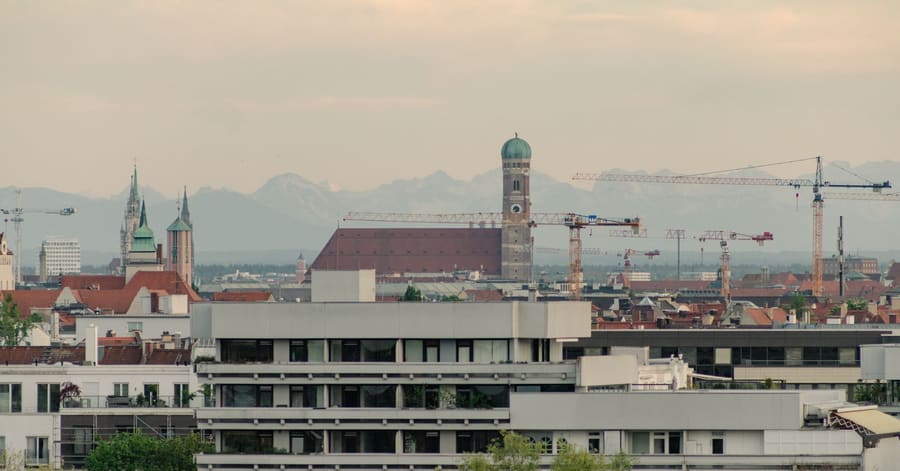 Scenic view of Munich skyline featuring the Frauenkirche and surrounding architecture at sunset.