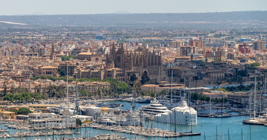 Explore the picturesque skyline of Palma de Mallorca featuring La Seu Cathedral and the bustling marina.