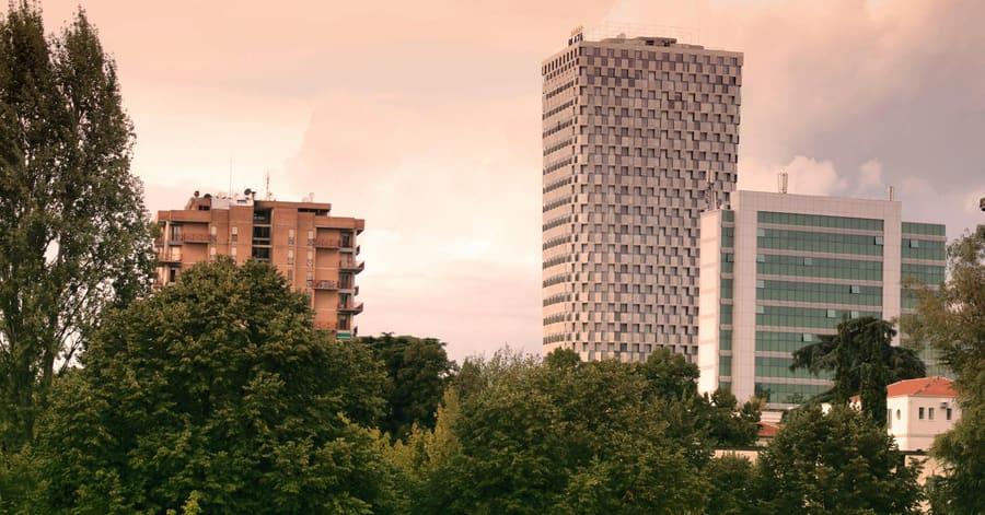 View of modern skyscrapers and lush greenery in Tirana, Albania during daylight.