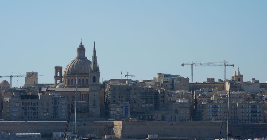Beautiful view of Valletta with boats in foreground, highlighting iconic architecture under a clear blue sky.